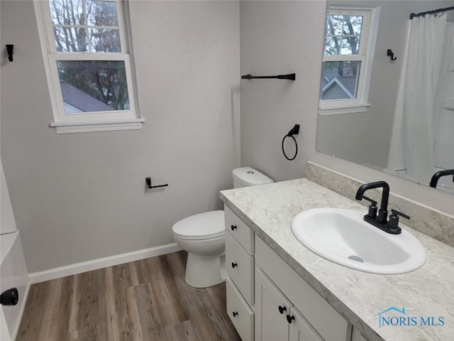 full bathroom featuring wood finished floors, vanity, baseboards, toilet, and a shower with shower curtain
