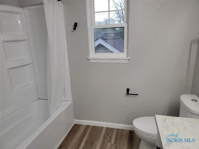 bathroom with vanity, toilet, shower / bath combo with shower curtain, baseboards, and wood finished floors