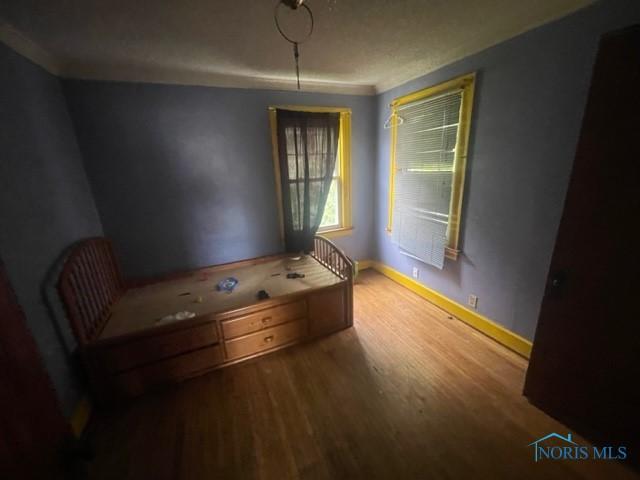 2004 Calumet Ave, Toledo, OH 43607 - unfurnished bedroom featuring crown molding, baseboards, and wood finished floors