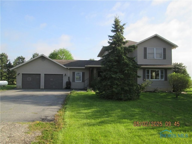 view of front of house with an attached garage, driveway, and a front yard