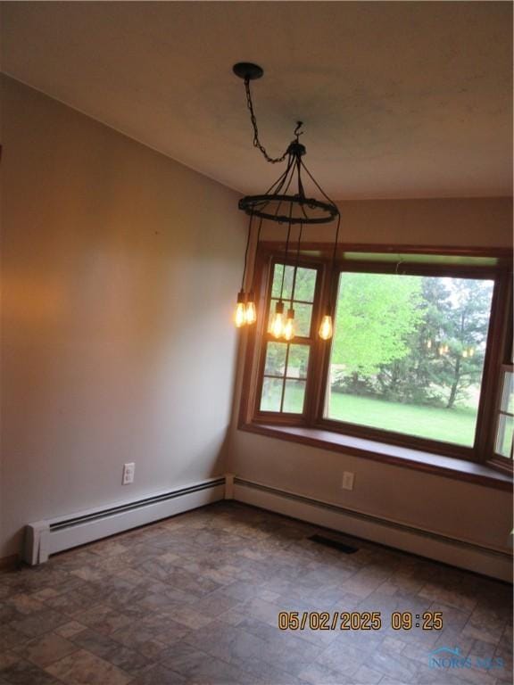 empty room featuring baseboard heating, a baseboard heating unit, and a wealth of natural light