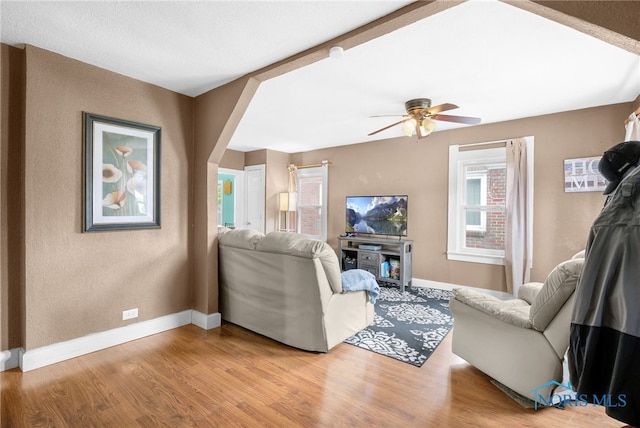 4835 291st St, Toledo, OH 43611 - living room with baseboards, light wood finished floors, arched walkways, a ceiling fan, and a textured wall