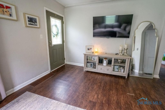 entrance foyer with baseboards, arched walkways, and wood finished floors