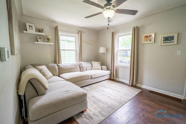 living area featuring visible vents, a ceiling fan, plenty of natural light, and wood finished floors