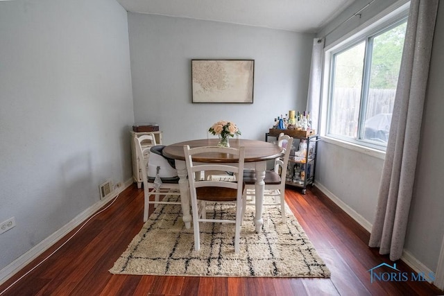 dining room featuring baseboards, wood finished floors, and visible vents