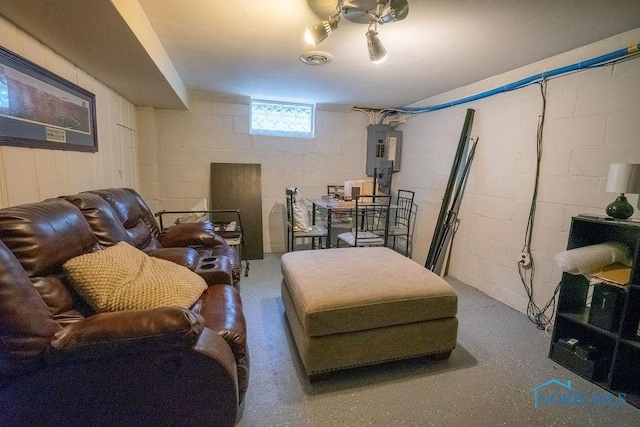 living room featuring concrete block wall, visible vents, and electric panel