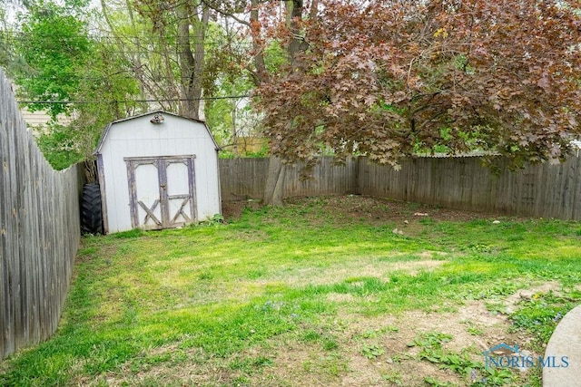 view of yard with an outbuilding, a fenced backyard, and a shed