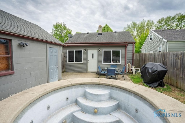 rear view of property with roof with shingles, fence, a chimney, and a patio area