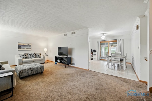 living room featuring crown molding, ceiling fan, light carpet, baseboards, and visible vents