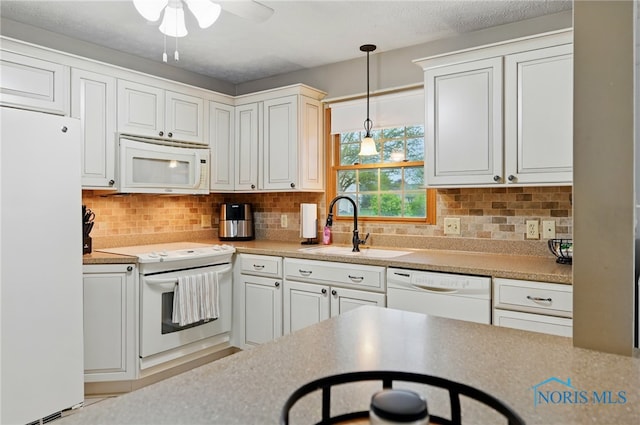 kitchen featuring decorative backsplash, a ceiling fan, hanging light fixtures, a sink, and white appliances