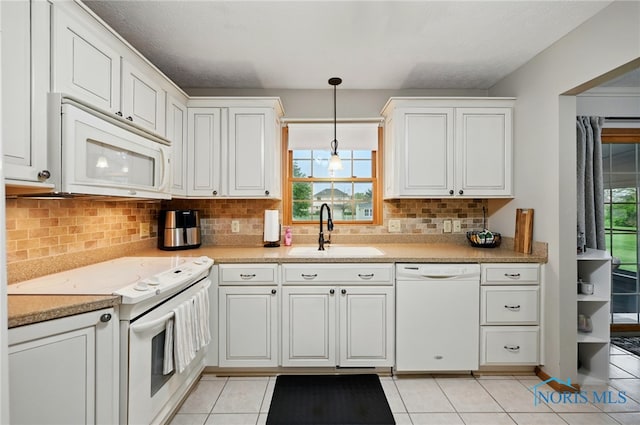 kitchen featuring decorative backsplash, decorative light fixtures, a sink, light tile patterned floors, and white appliances