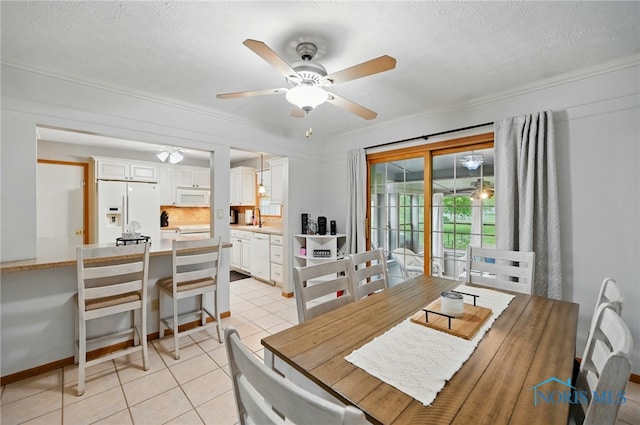 dining room featuring crown molding, a ceiling fan, a textured ceiling, and light tile patterned floors