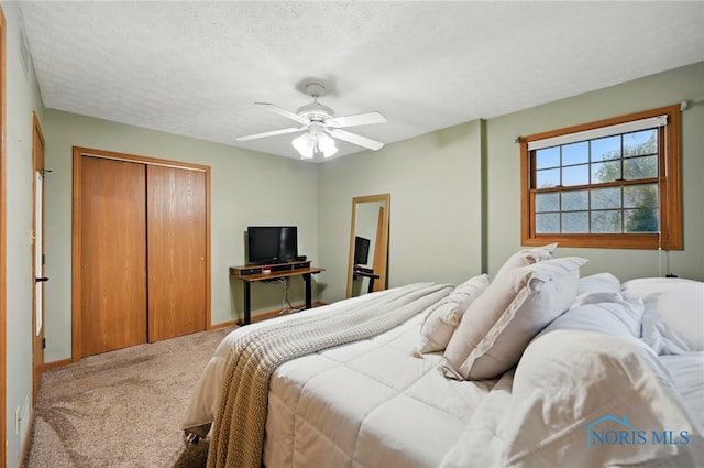 bedroom featuring carpet flooring, ceiling fan, a textured ceiling, baseboards, and a closet