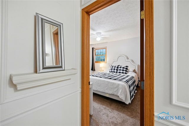 carpeted bedroom with a textured ceiling and ceiling fan