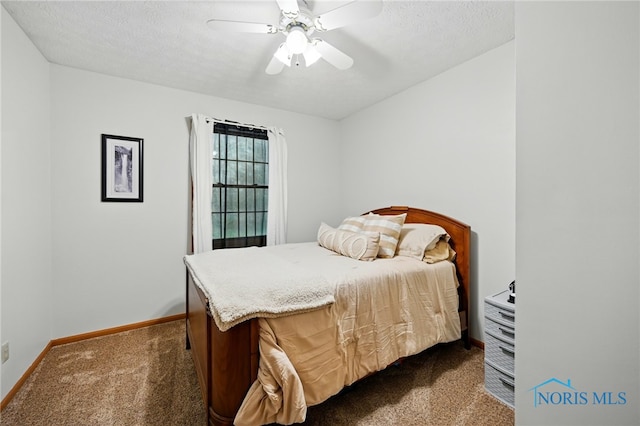 bedroom featuring a ceiling fan, baseboards, a textured ceiling, and dark colored carpet