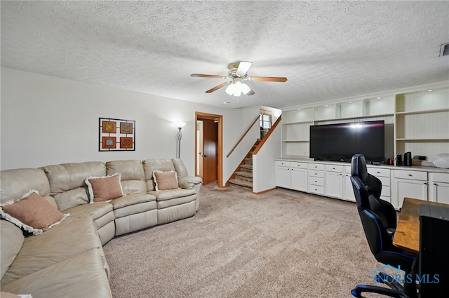 home office featuring light colored carpet, a ceiling fan, and a textured ceiling