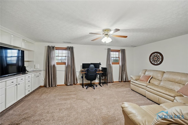living room with a ceiling fan, a textured ceiling, and light carpet