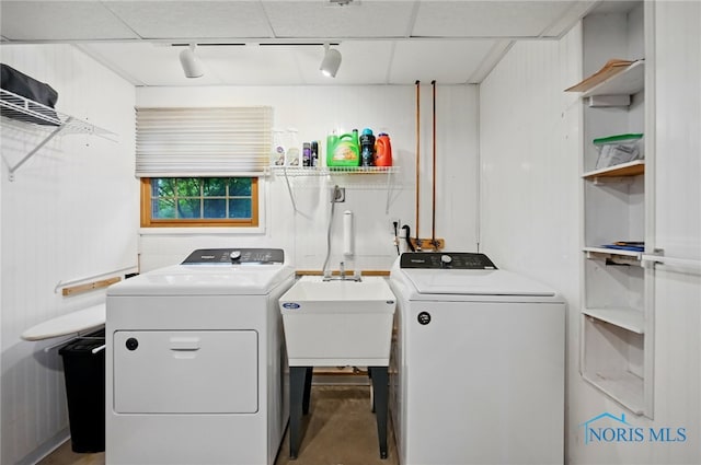 laundry area featuring track lighting, laundry area, washing machine and dryer, and a sink