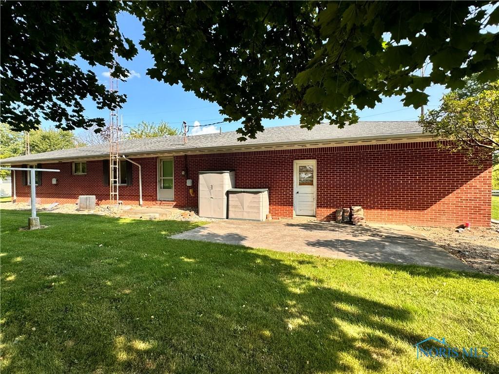 view of front of home featuring brick siding, a patio, and a front yard
