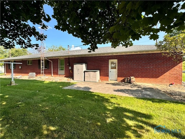 view of front of home featuring brick siding, a patio, and a front yard