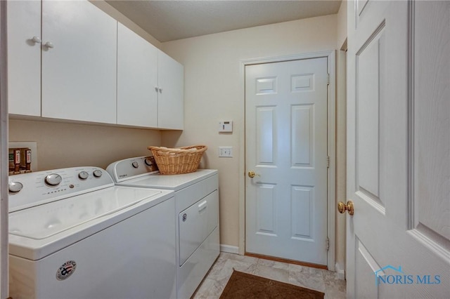 laundry area with baseboards, cabinet space, and washer and clothes dryer