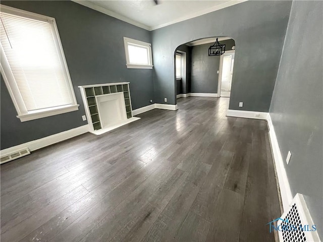 1741 Berkshire Pl, Toledo, OH 43613 - unfurnished living room with arched walkways, crown molding, dark wood-style flooring, and baseboards