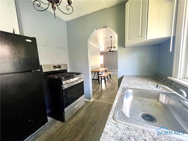1949 Marlow Rd, Toledo, OH 43613 - kitchen with freestanding refrigerator, stainless steel range with gas cooktop, a chandelier, a sink, and dark wood finished floors