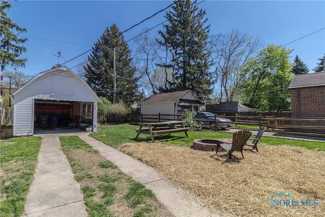 1407 Kenyon Dr, Toledo, OH 43614 - view of yard featuring a fire pit, a garage, and an outbuilding