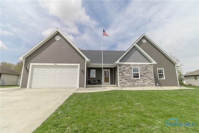 749 Parkside Dr, Wauseon, OH 43567 - view of front of house featuring an attached garage, a front lawn, stone siding, and concrete driveway