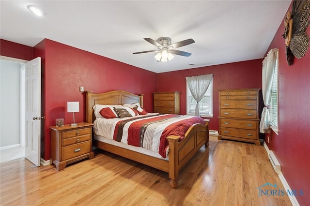106 N Munson Rd, Swanton, OH 43558 - bedroom featuring light wood finished floors, a baseboard heating unit, baseboards, and a ceiling fan