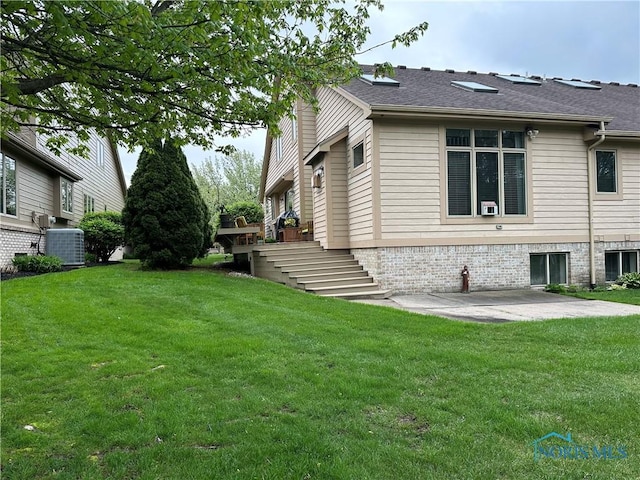 view of side of home featuring a lawn, central AC unit, a patio area, and stairs