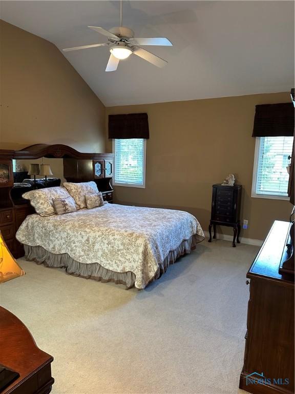 bedroom featuring a ceiling fan, baseboards, light carpet, and vaulted ceiling