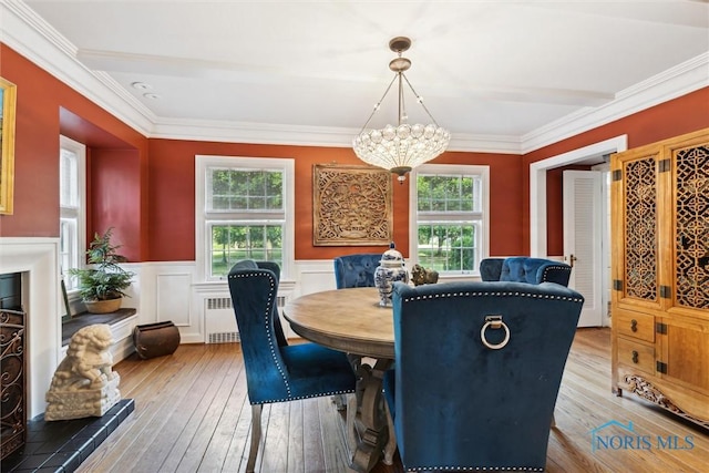 3766 Edgevale Rd, Toledo, OH 43606 - dining area with radiator heating unit, light wood finished floors, a chandelier, a wainscoted wall, and ornamental molding