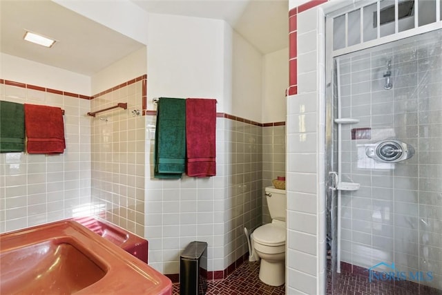 3766 Edgevale Rd, Toledo, OH 43606 - bathroom with tile walls, a shower stall, tile patterned floors, and toilet