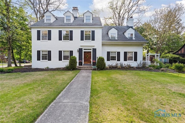 3766 Edgevale Rd, Toledo, OH 43606 - view of front of home with stucco siding, a chimney, and a front yard