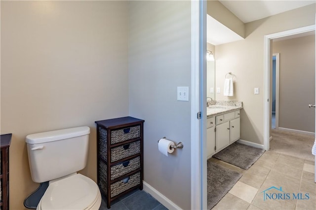 bathroom featuring toilet, baseboards, tile patterned flooring, and vanity
