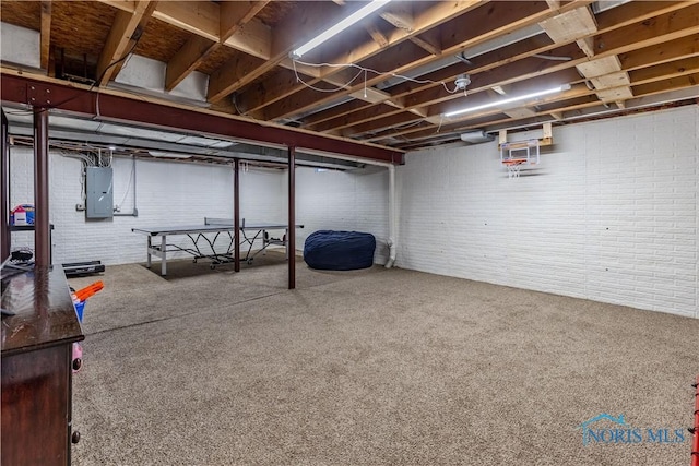 unfinished basement featuring carpet, brick wall, and electric panel