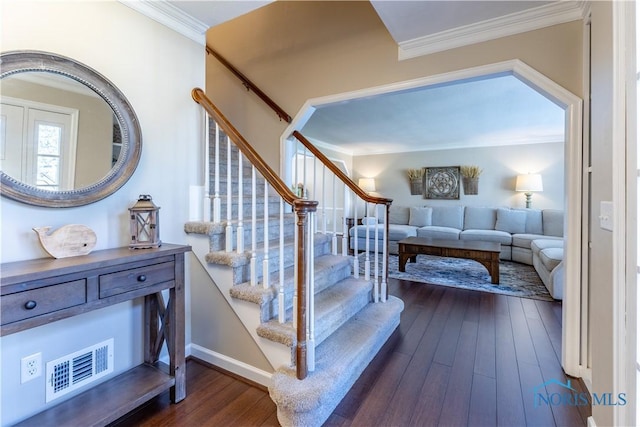 stairs featuring wood-type flooring, crown molding, visible vents, and baseboards