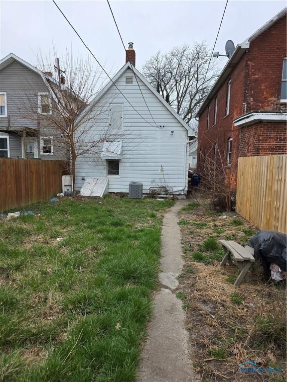 362 Burger St, Toledo, OH 43605 - rear view of house with fence, a chimney, and cooling unit