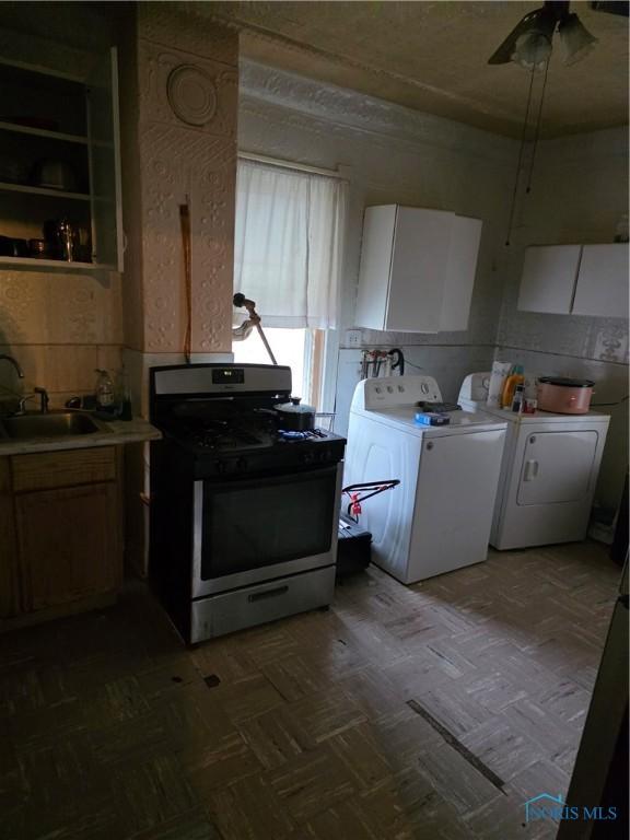 362 Burger St, Toledo, OH 43605 - kitchen with a sink, light countertops, a ceiling fan, gas range, and washer and clothes dryer
