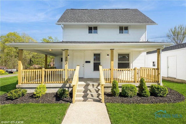 303 Short St, Napoleon, OH 43545 - country-style home with roof with shingles, covered porch, and a front lawn