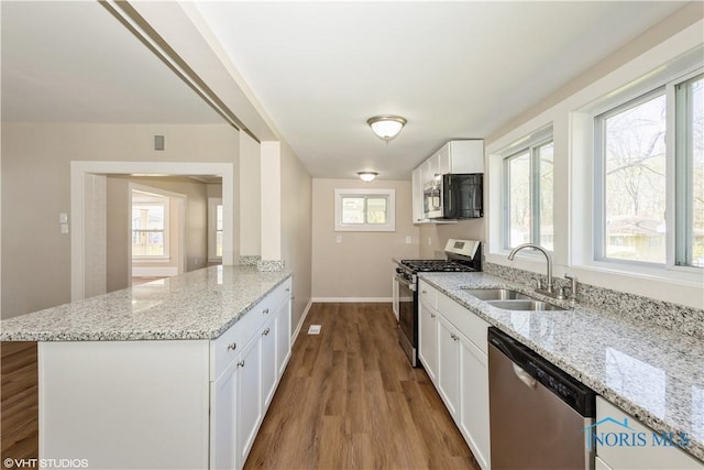 303 Short St, Napoleon, OH 43545 - kitchen with white cabinets, stainless steel appliances, a sink, and a peninsula