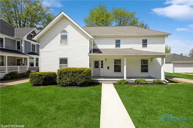 traditional-style home featuring a porch and a front lawn