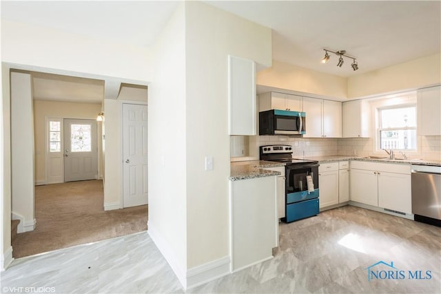 kitchen featuring backsplash, stainless steel dishwasher, range with electric stovetop, and light stone countertops