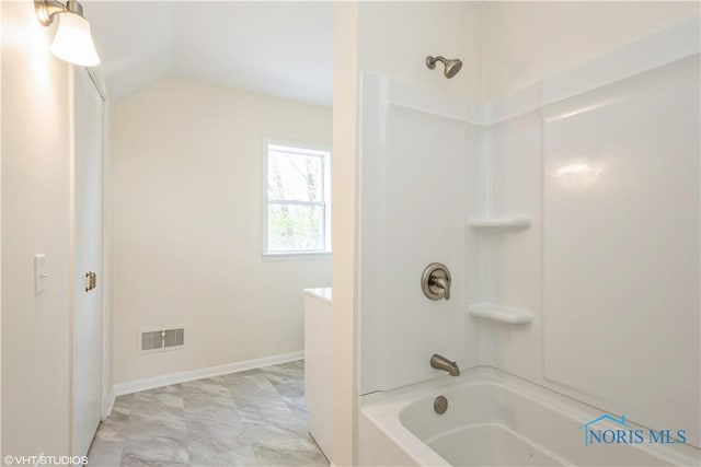 bathroom with visible vents, baseboards, marble finish floor,  shower combination, and lofted ceiling