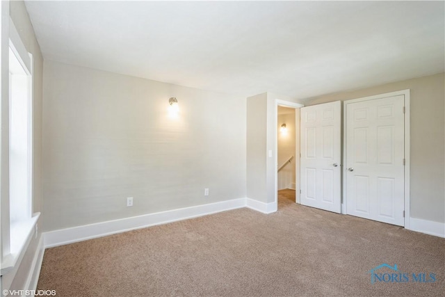 unfurnished bedroom with carpet flooring and baseboards