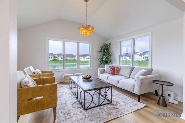 26328 Stillwater Dr, Perrysburg, OH 43551 - living area featuring plenty of natural light, lofted ceiling, wood finished floors, a chandelier, and baseboards
