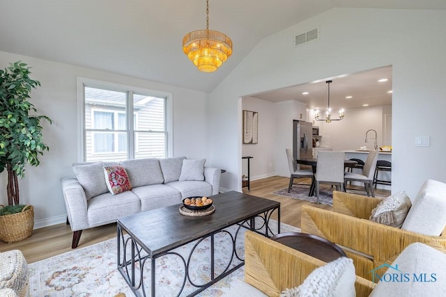 26328 Stillwater Dr, Perrysburg, OH 43551 - living area with a chandelier, light wood-style flooring, baseboards, recessed lighting, and high vaulted ceiling