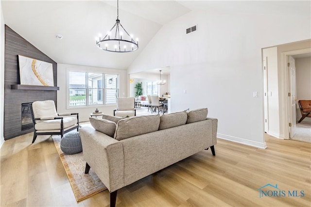 26328 Stillwater Dr, Perrysburg, OH 43551 - living area with a chandelier, light wood-type flooring, high vaulted ceiling, a large fireplace, and baseboards