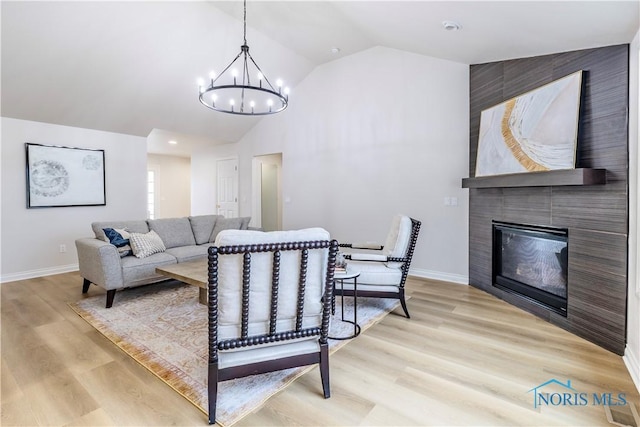 26328 Stillwater Dr, Perrysburg, OH 43551 - living room with vaulted ceiling, a chandelier, baseboards, a fireplace, and light wood-type flooring